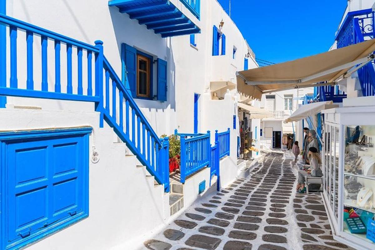 una strada stretta con porte blu su edifici bianchi