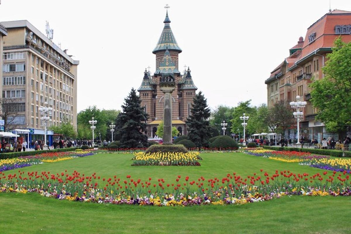 et klokketårn midt i en park med blomster