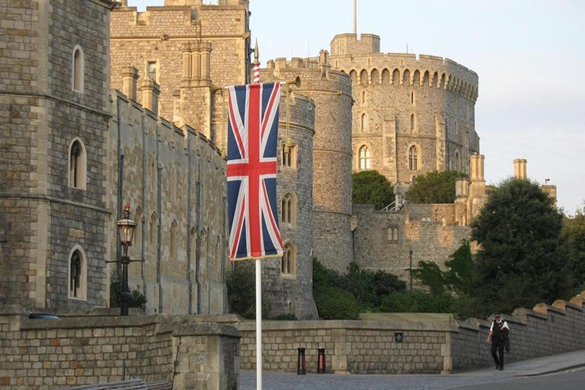 a british flag on a pole in front of a castle