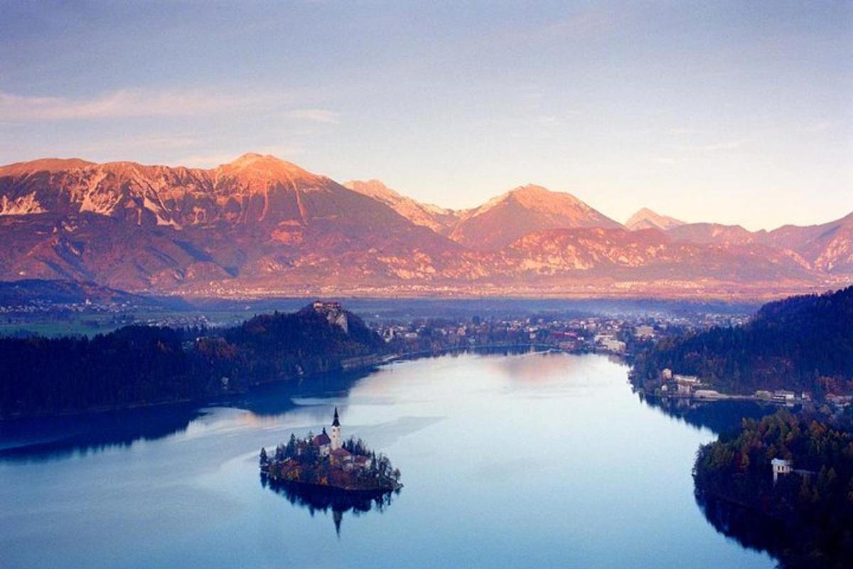 an island in the middle of a lake with mountains