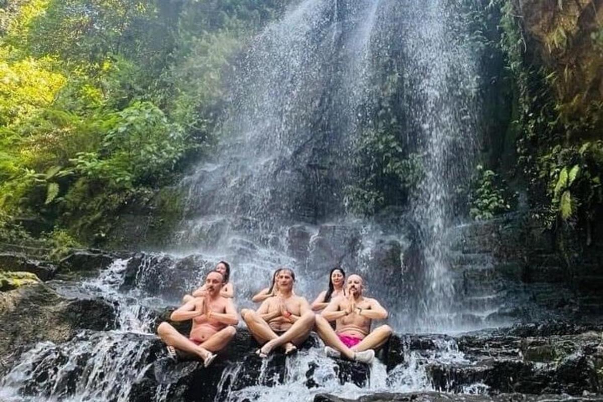 empat wanita duduk di atas batu di hadapan air terjun