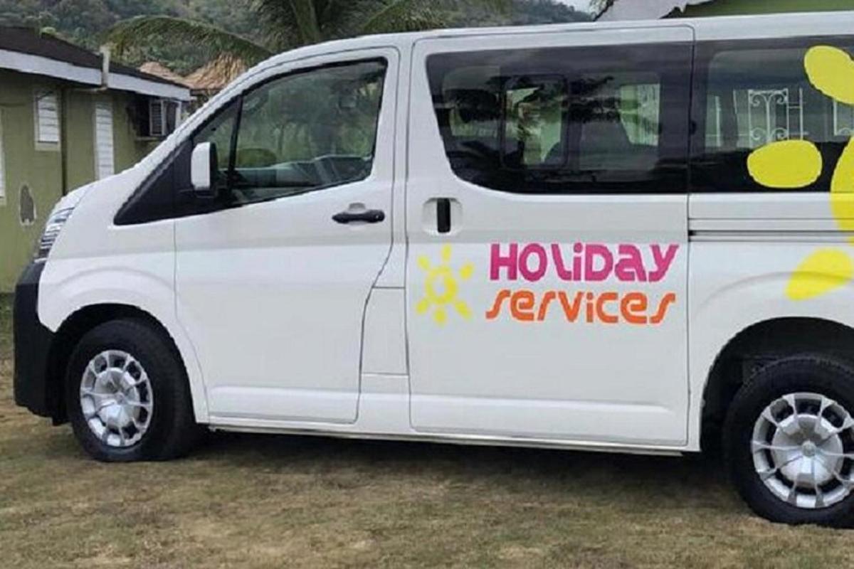 sebuah van putih dengan papan tanda terbalik percutian padanya