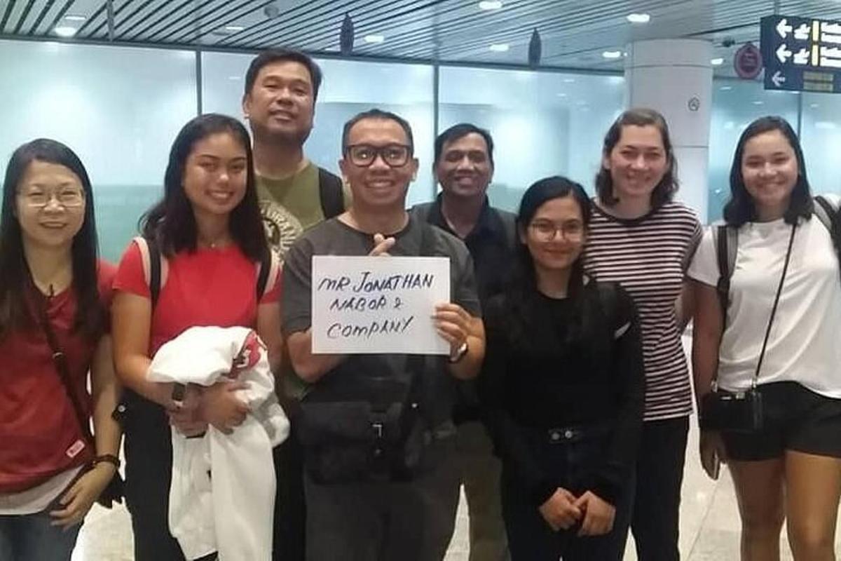 un grup de persones posant per a una foto amb un cartell