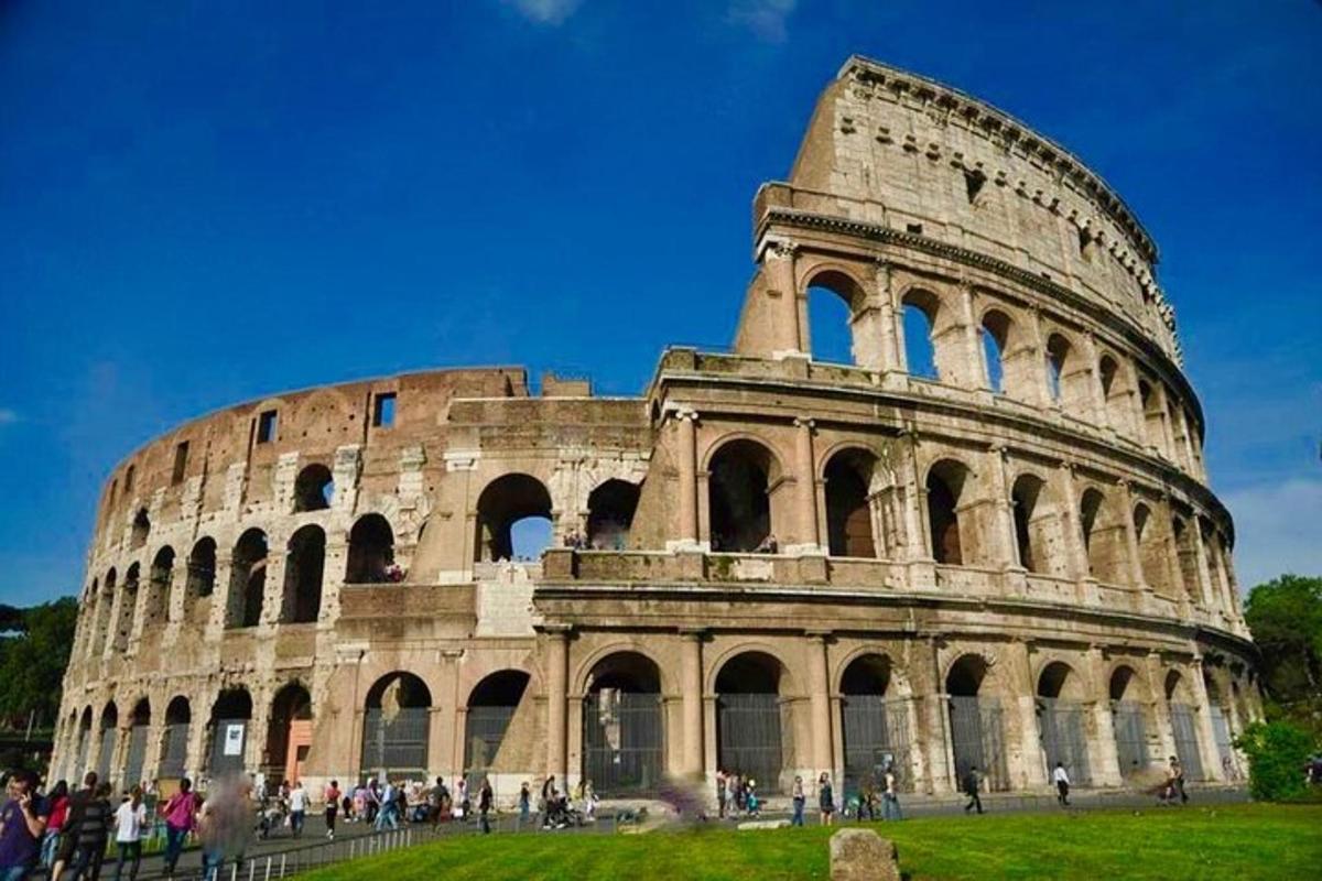 un gruppo di persone in piedi davanti al Colosseo