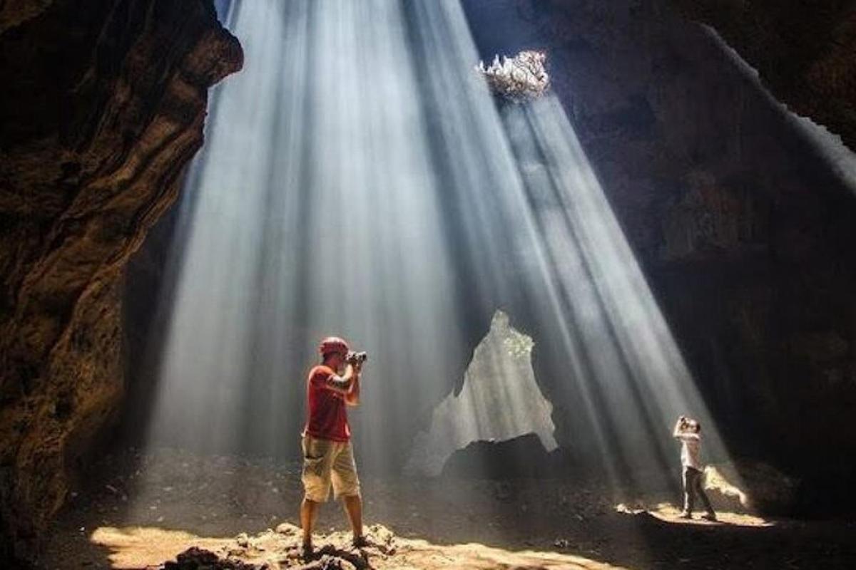 vīrietis fotografē ūdenskritumu
