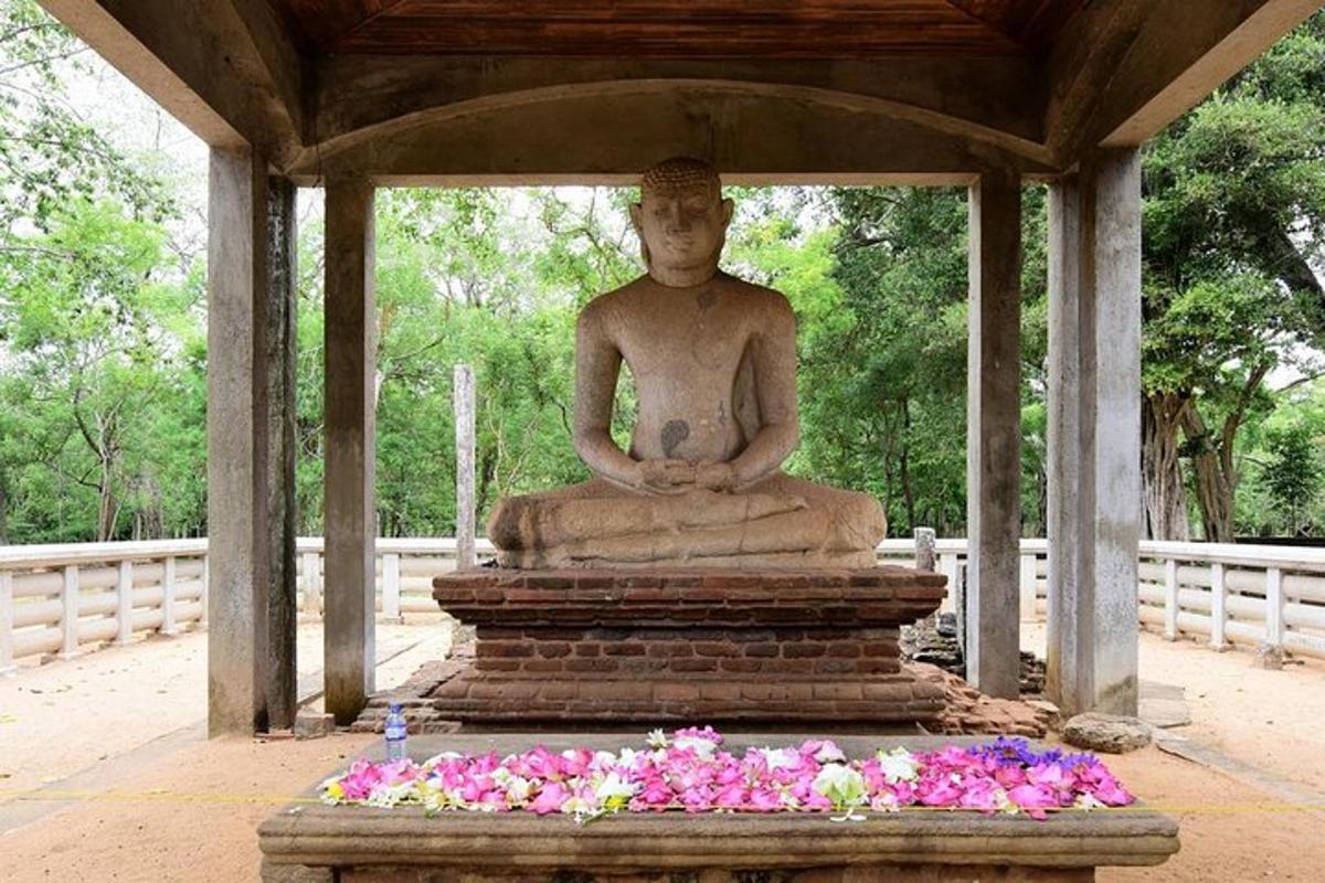 una grande statua seduta in cima a una visiera con fiori