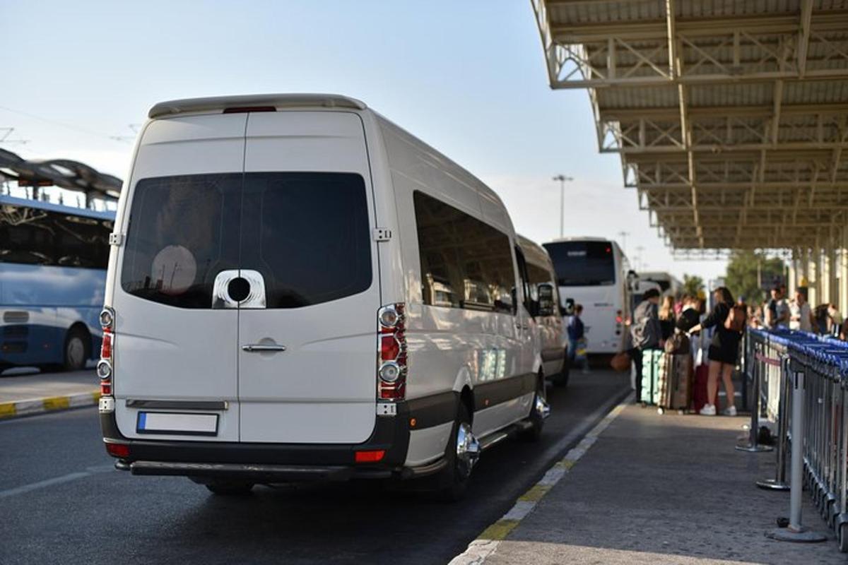 o dubă albă este parcată într-o stație de autobuz