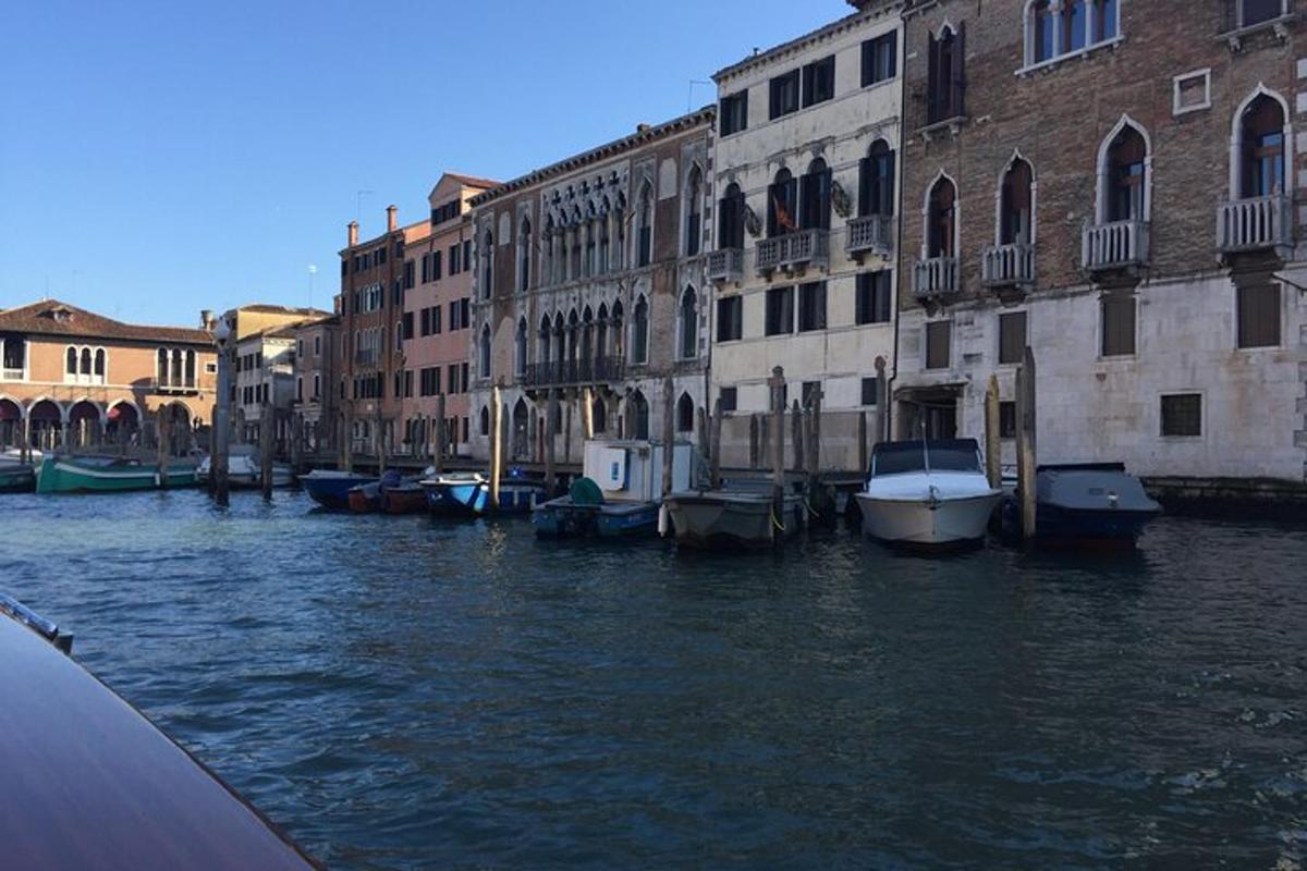 a group of boats docked in a canal with buildings
