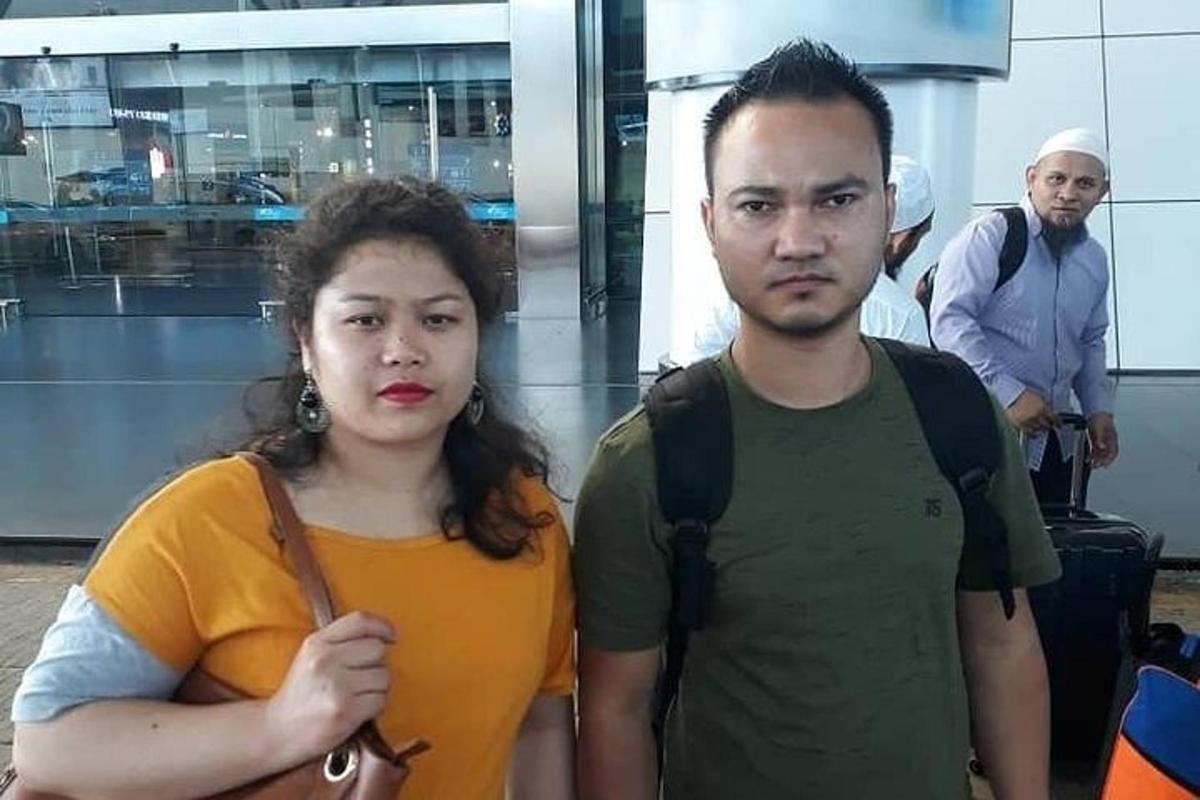 Un hombre y una mujer de pie en un aeropuerto