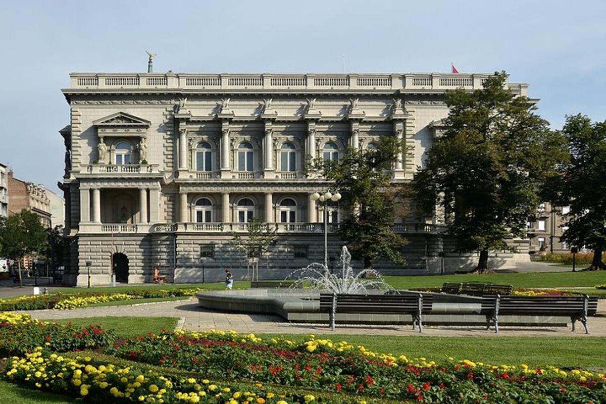 un grande edificio con una fontana di fronte