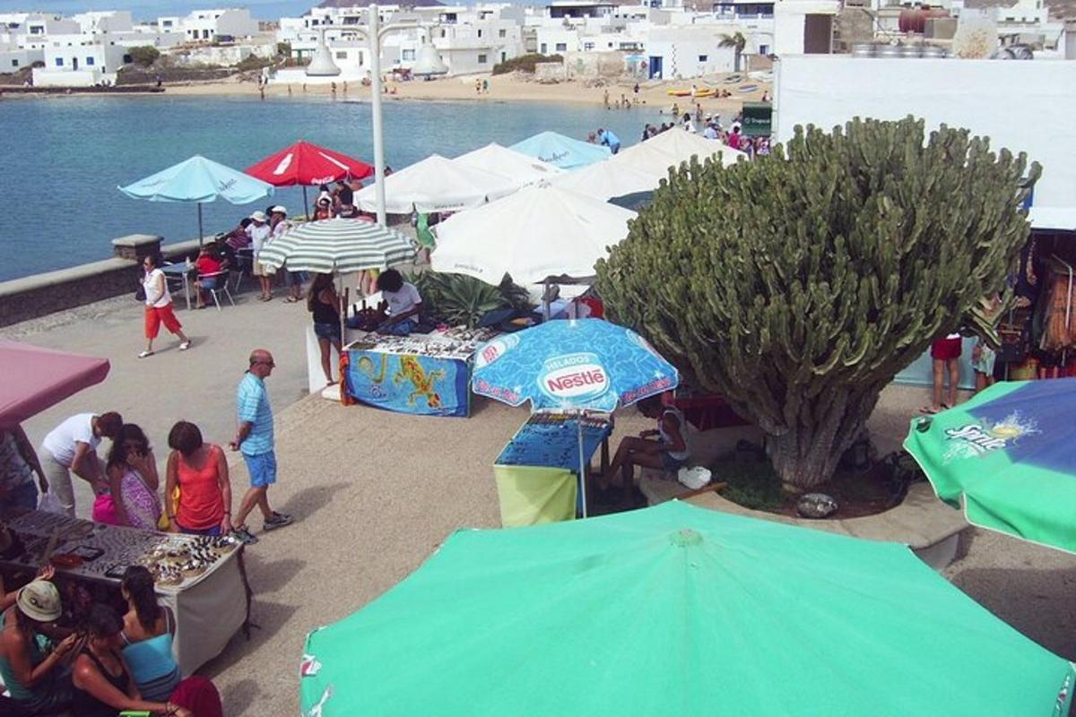 a group of people standing around a market with umbrellas