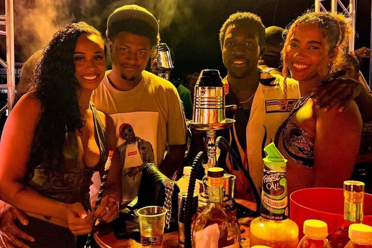 a group of people standing in front of a table with a drink