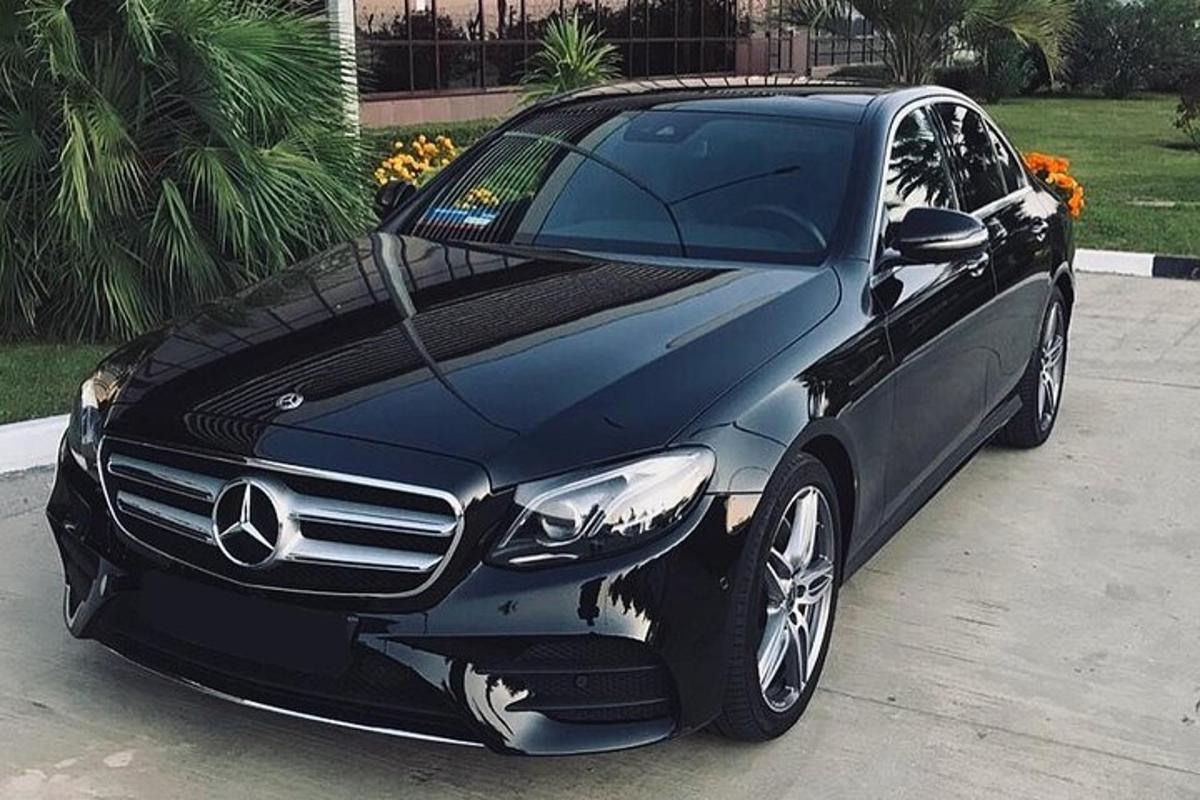 juodas „Mercedes Benz“ automobilis, pastatytas kieme