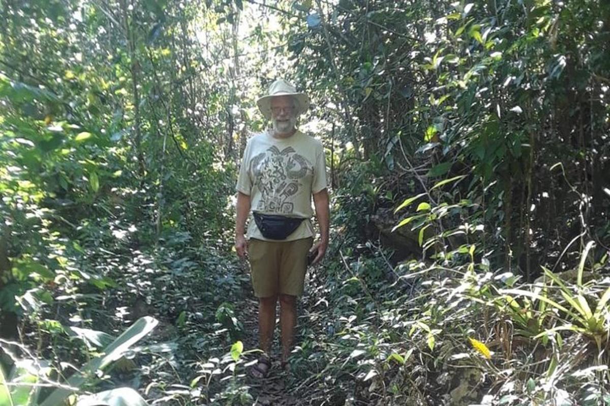 seorang lelaki berdiri di atas denai di dalam hutan
