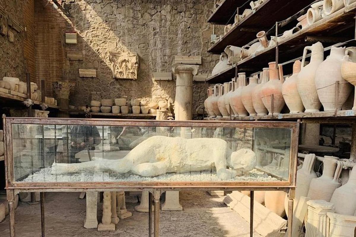 o vitrină cu o sculptură într-o cameră cu vaze