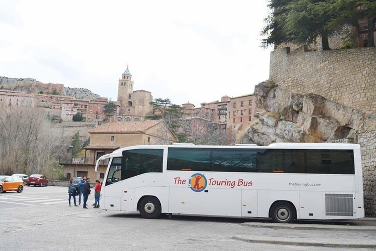 un autobus bianco parcheggiato in un parcheggio accanto a un edificio