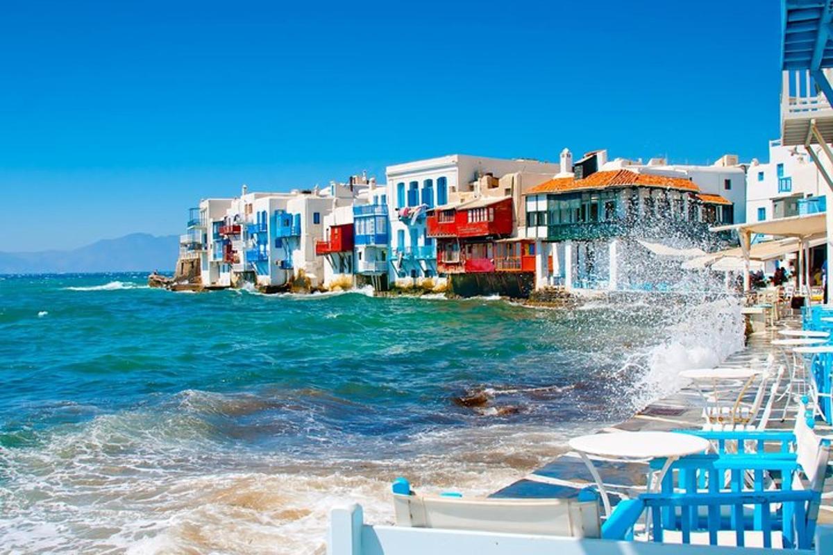 Una playa con sillas y edificios y el océano.