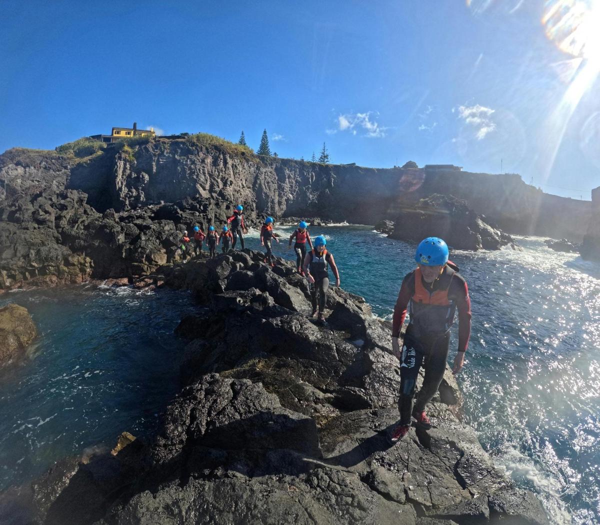 un gruppo di persone in piedi sulle rocce vicino all'acqua