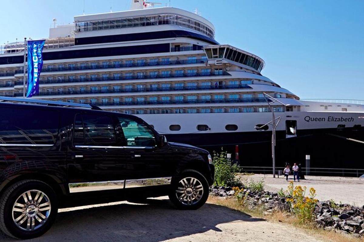 a black truck parked in front of a cruise ship