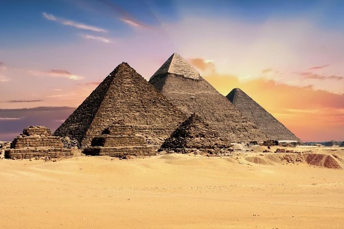 Skupina pyramid v poušti při západu slunce