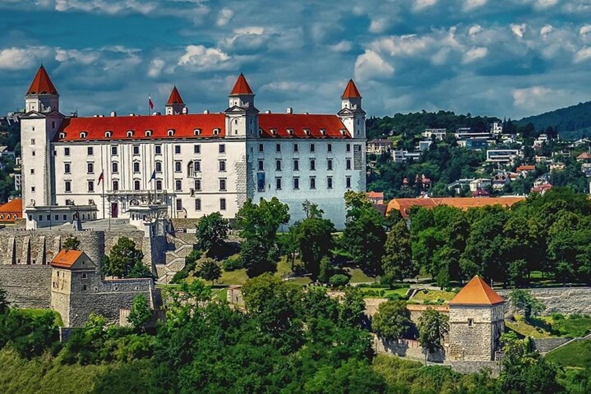 Velký bílý hrad s červenou střechou na kopci