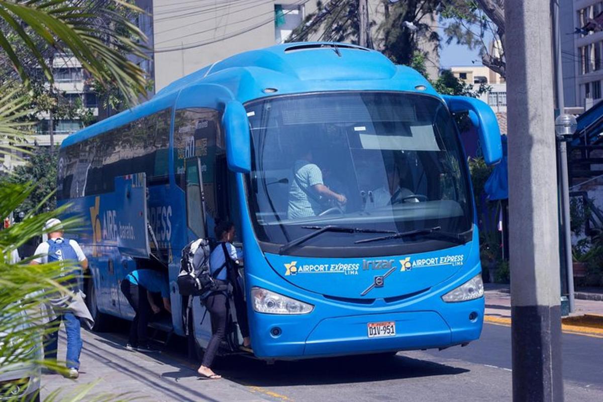 un autobus blu parcheggiato su una strada con persone che salgono
