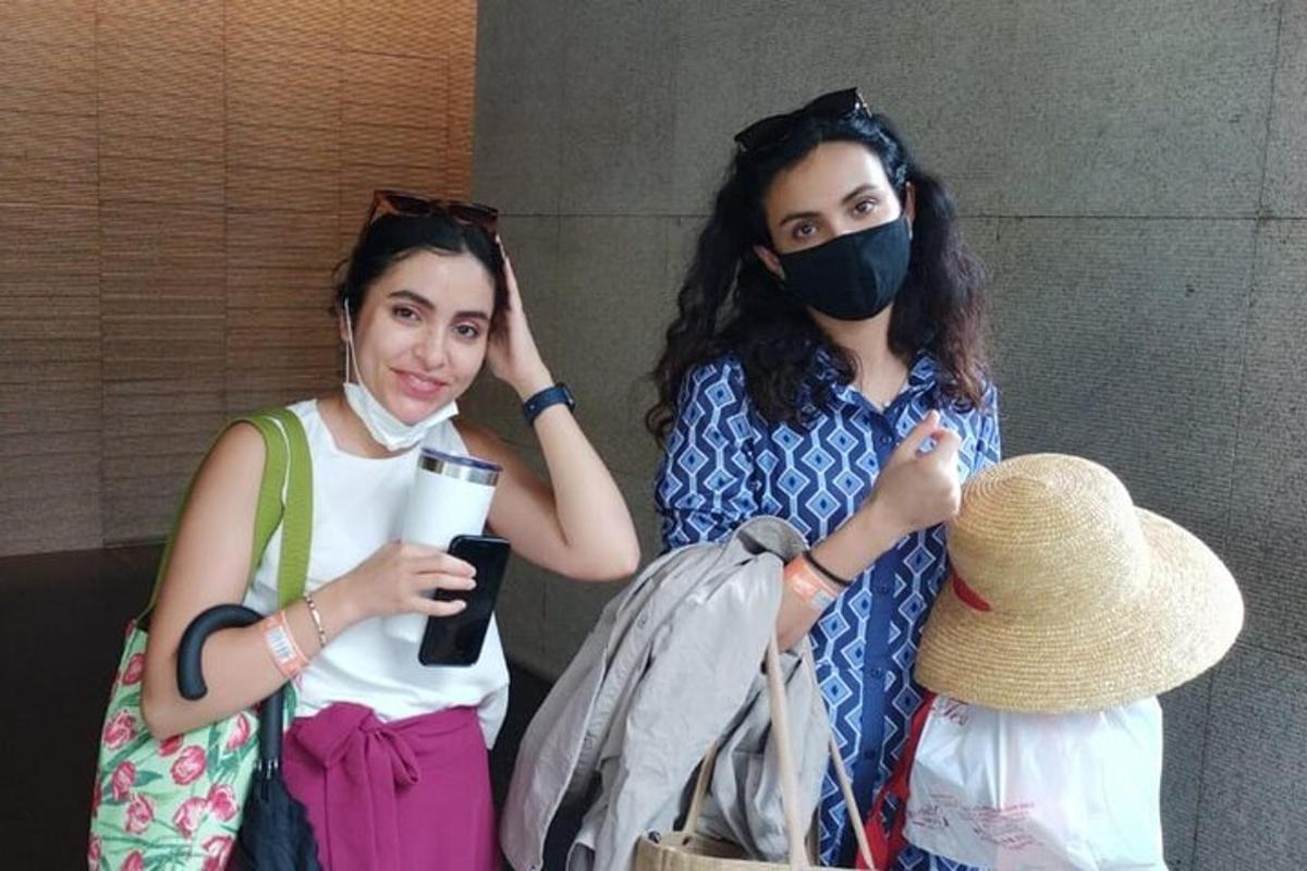 two women wearing masks standing next to each other