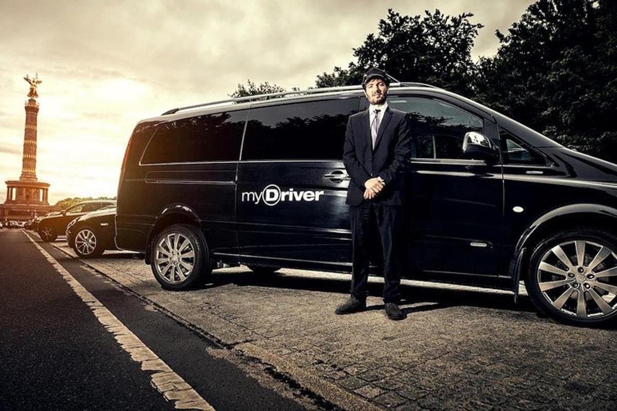 um homem de terno parado ao lado de uma minivan
