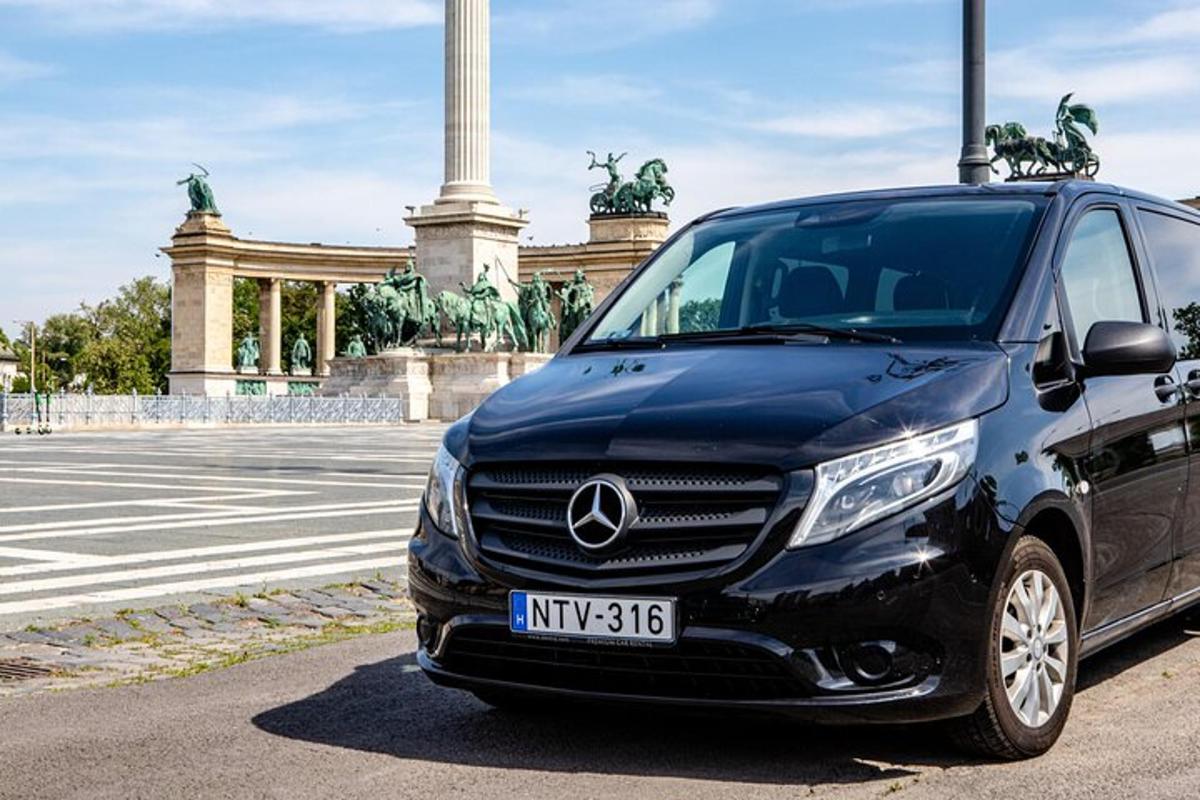 a blue car parked in front of a monument
