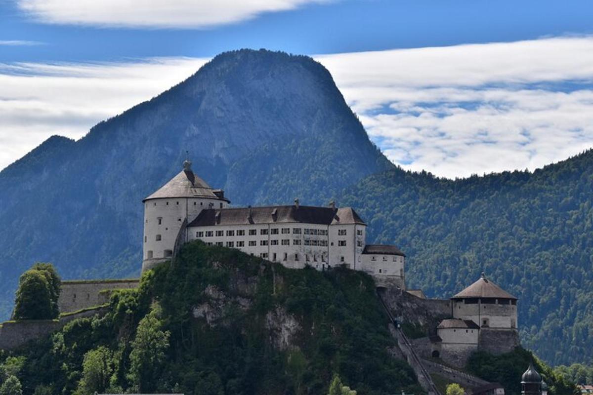 un castel pe un deal cu un munte în fundal
