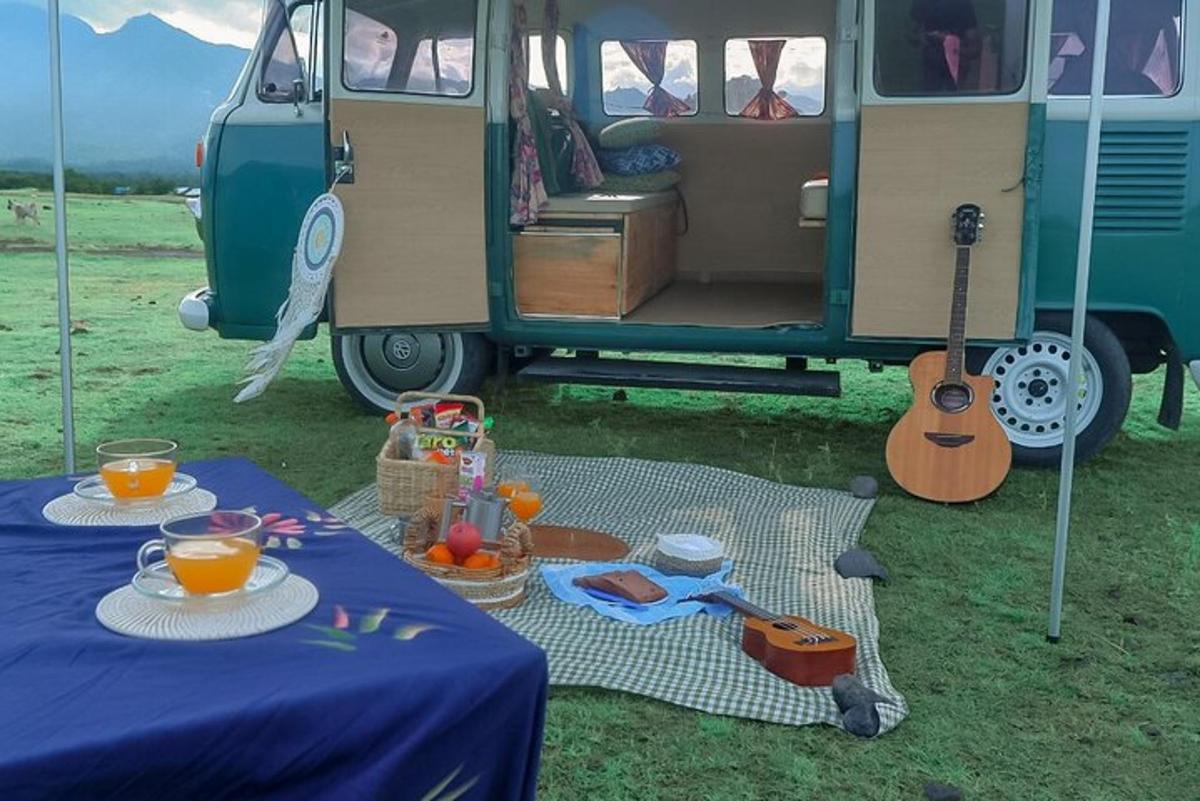 Una furgoneta con una mesa con comida y una guitarra.
