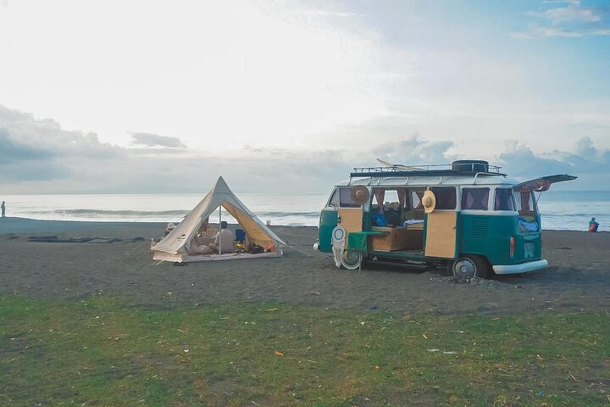 un furgone parcheggiato sulla spiaggia con una tenda
