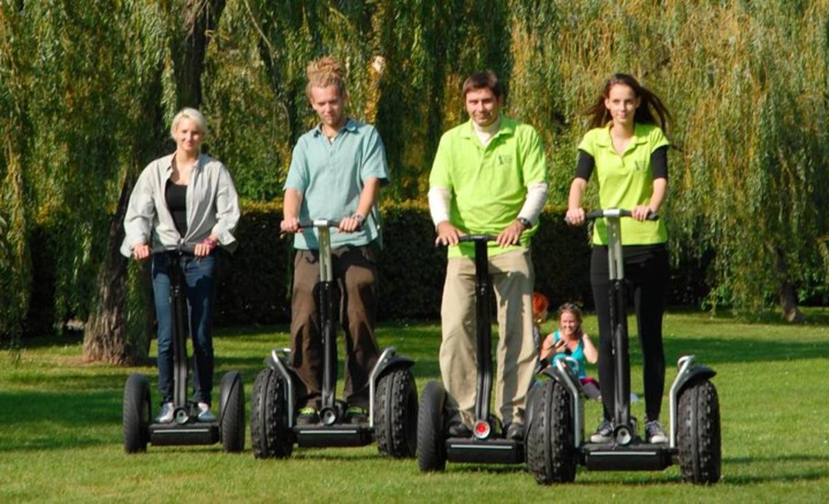 un gruppo di persone che guidano i segway in un parco