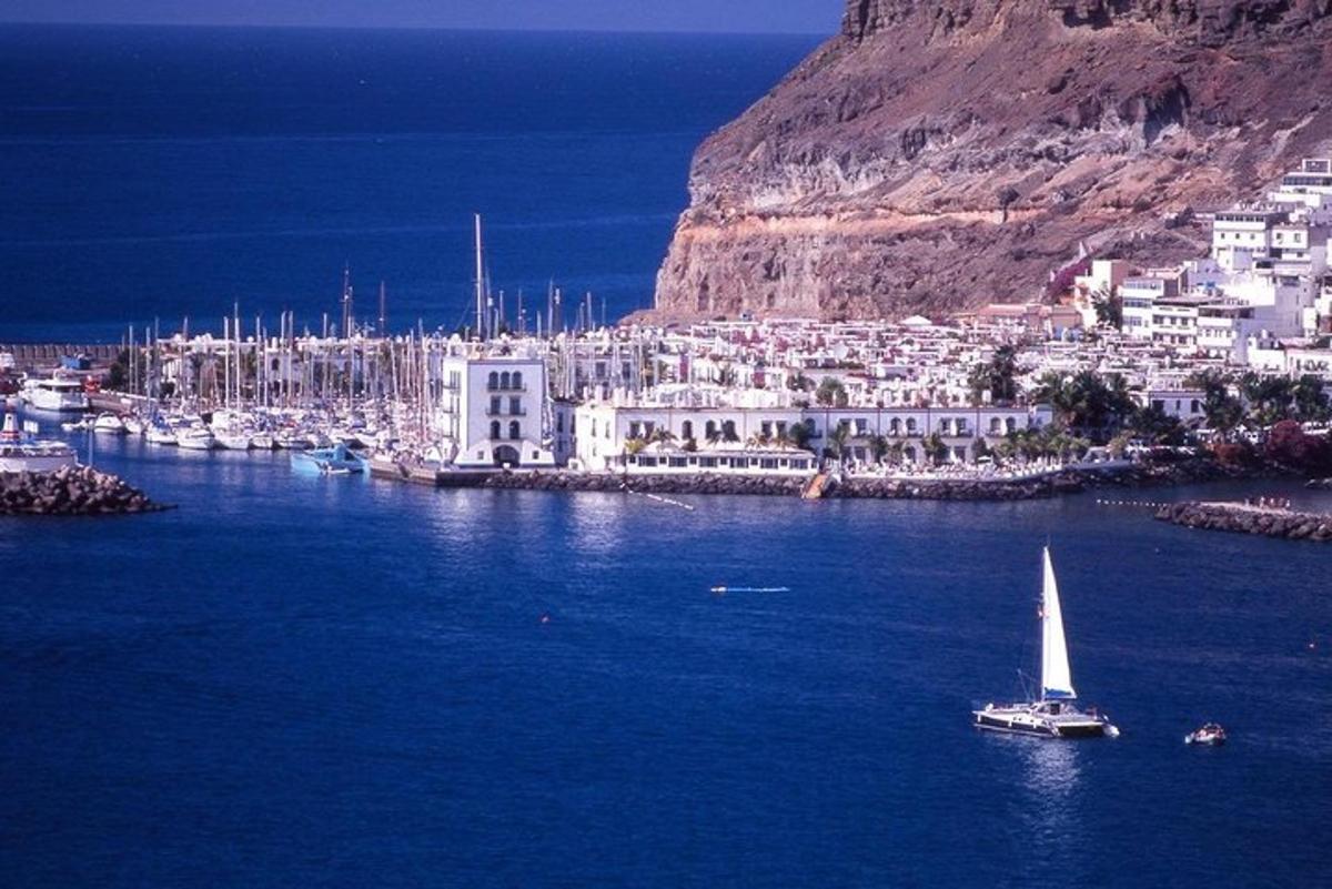 a sailboat in the water in front of a city