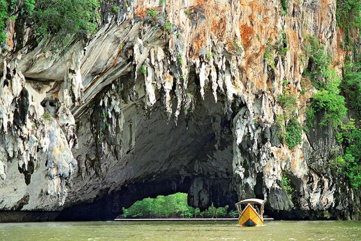một chiếc thuyền màu vàng trên mặt nước trước một hang động