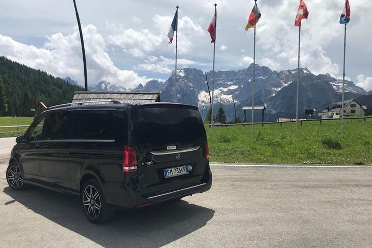 černé SUV zaparkované na parkovišti s vlajkami