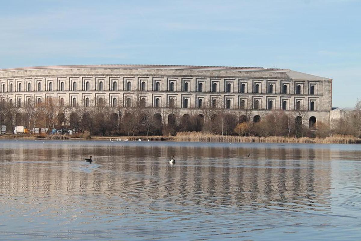 een groot gebouw met twee eenden in het water
