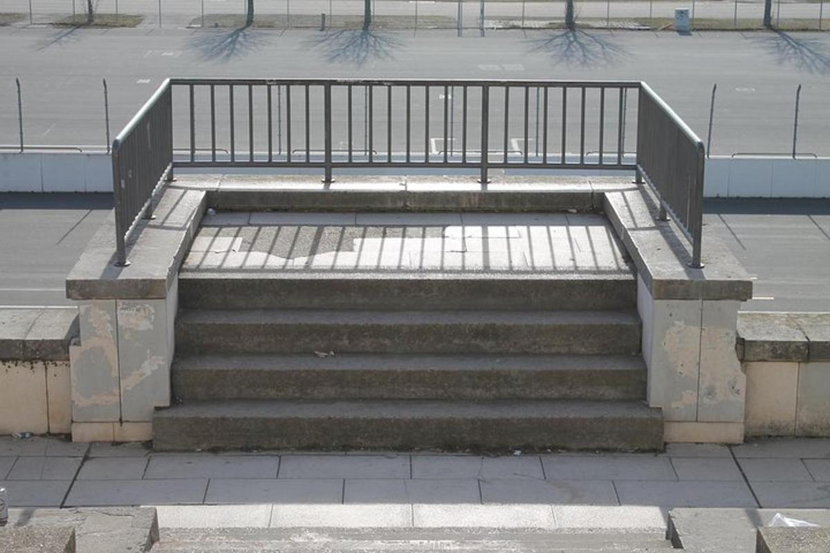 een betonnen trap met een metalen leuning