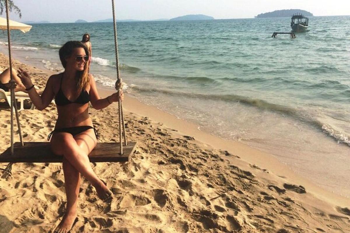 Žena v bikinách sedící na houpačce na pláži