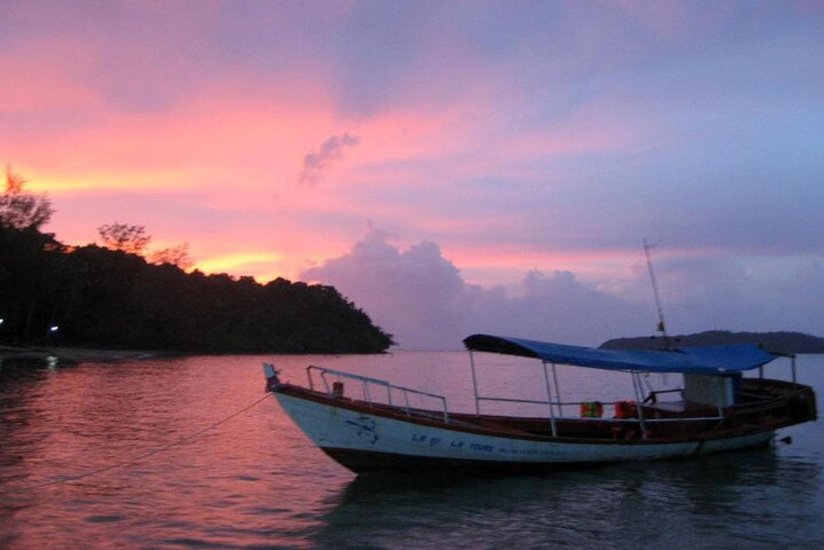 una barca in acqua con un tramonto sullo sfondo