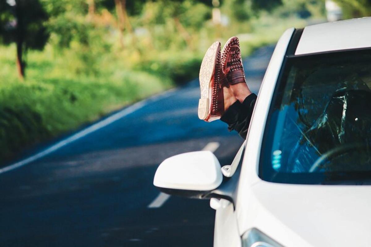 una persona che sporge i piedi dal finestrino di un'auto
