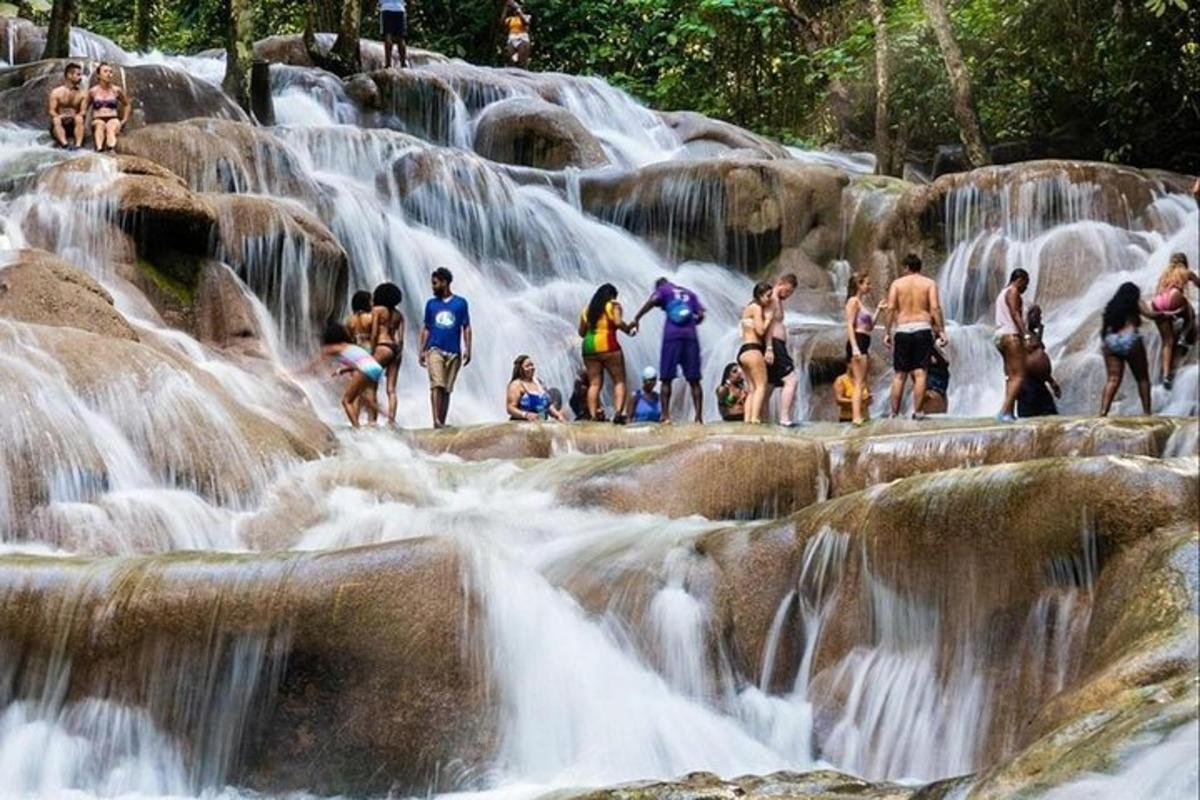 eine Gruppe von Menschen steht vor einem Wasserfall