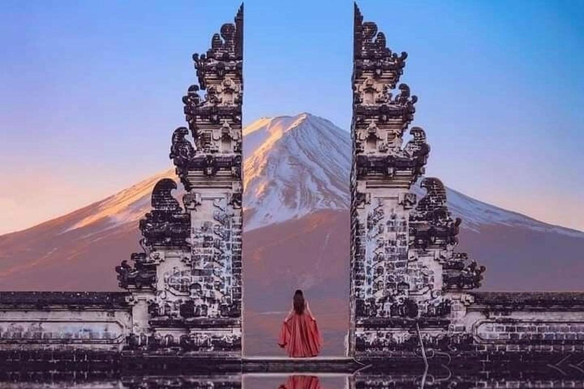a woman standing in front of a statue with a mountain in the background