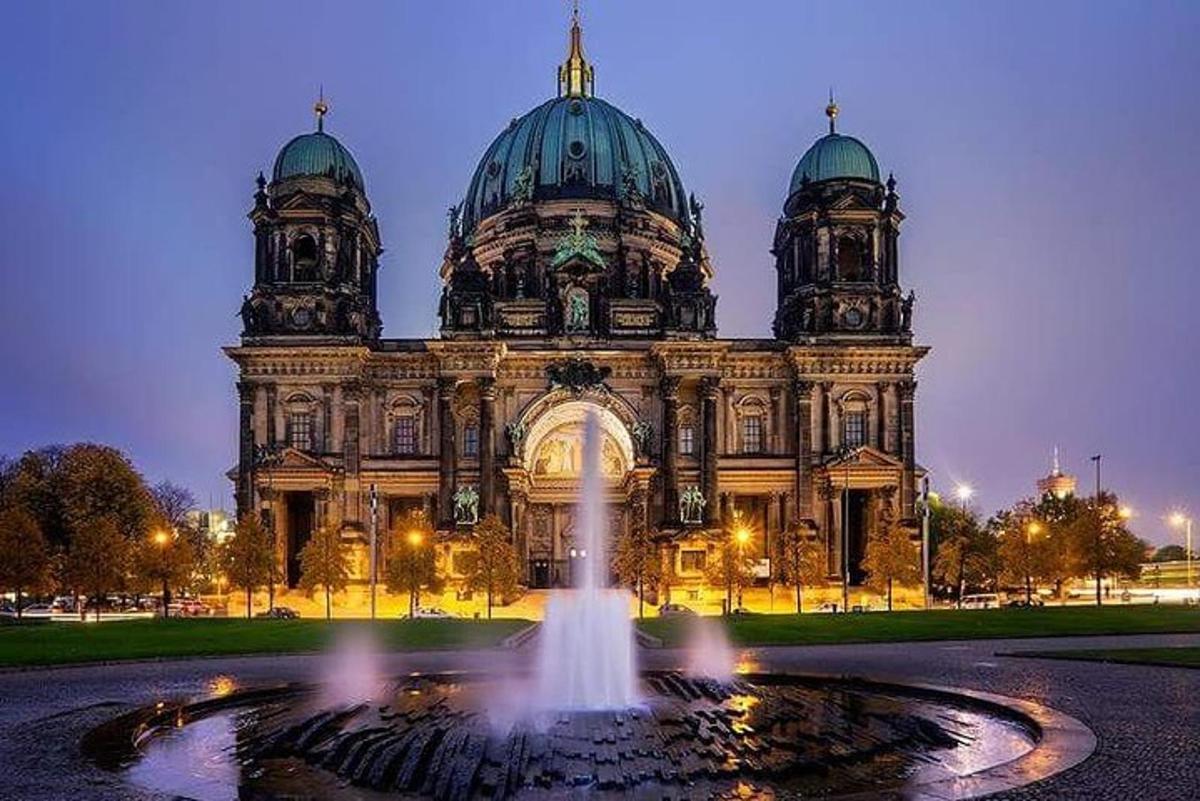 un grande edificio con una fontana di fronte
