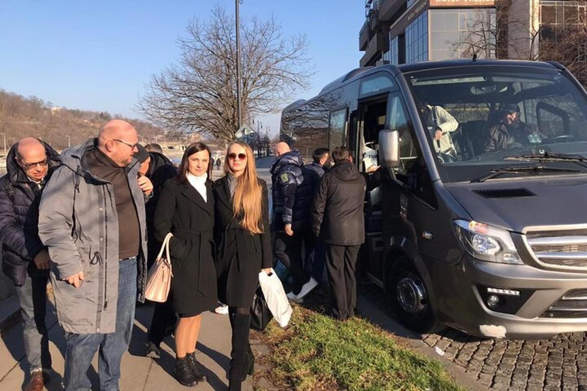 skupina lidí stojících před autobusem