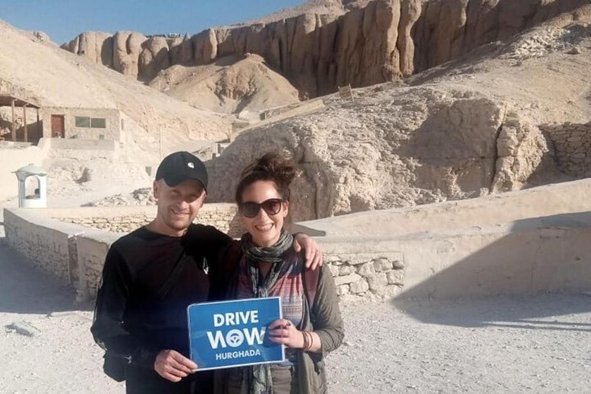 een man en een vrouw die een bord vasthouden in de woestijn