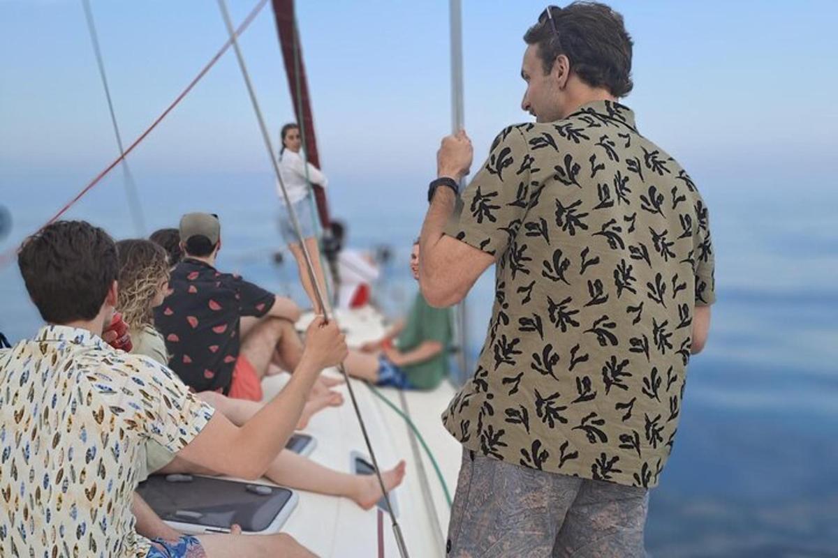 muž stojící na lodi se skupinou lidí