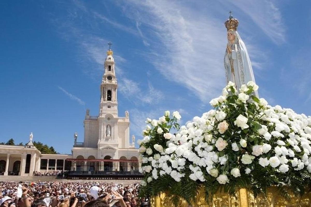 Una multitud de personas de pie frente a un edificio con una iglesia.