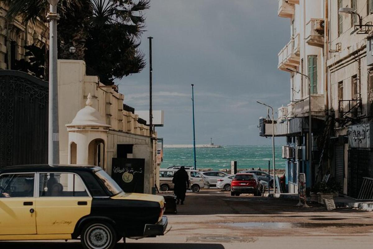 um velho carro amarelo estacionado em uma rua perto do oceano