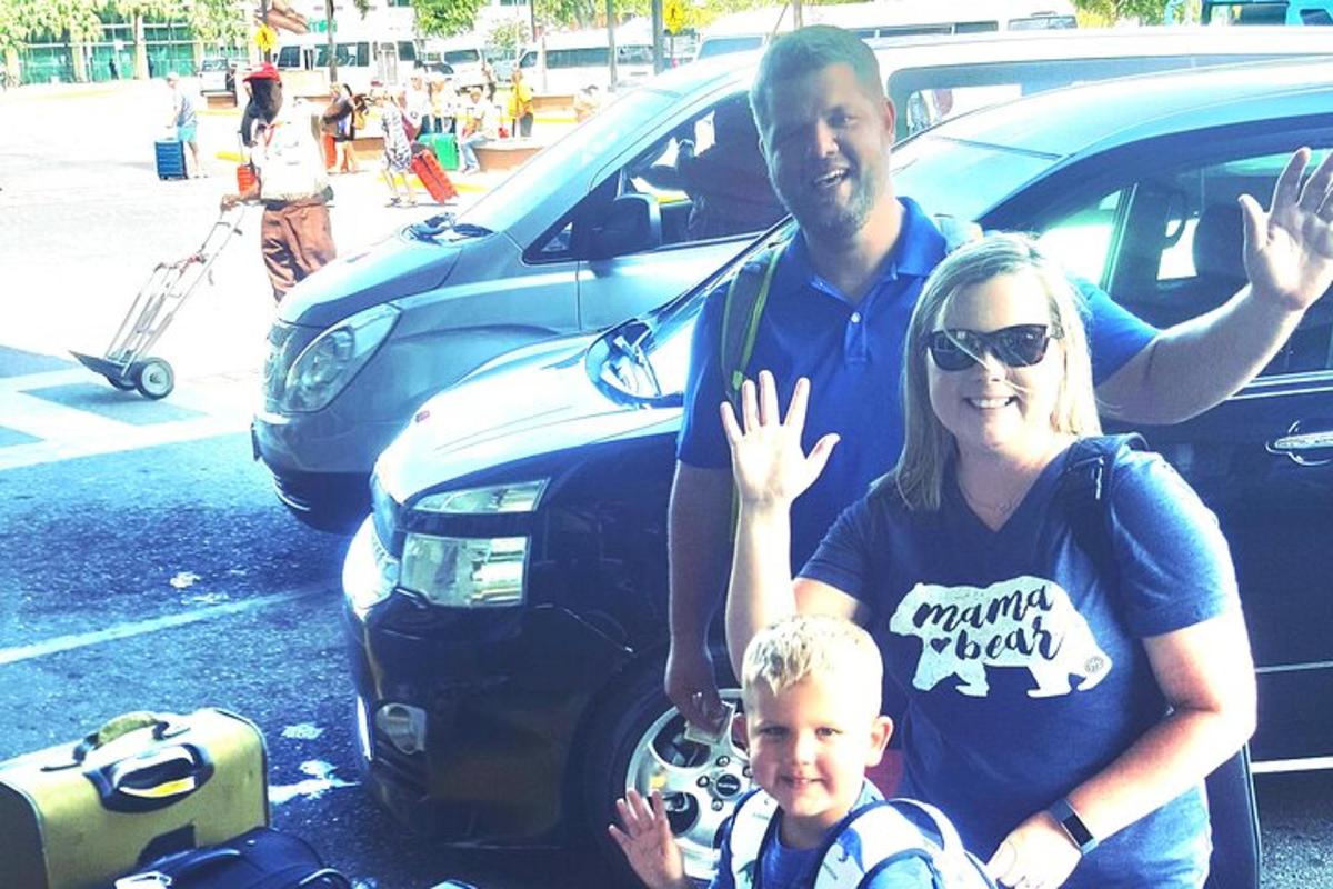 vīrietis, sieviete un bērns stāv blakus automašīnai